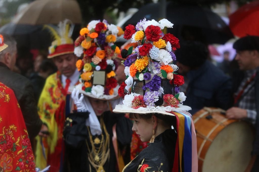 Detalle de los vistosos sombreros que lucen las Damas. A la derecha, arriba, un momento del baile, seguido bajo la lluvia por numeroso público.