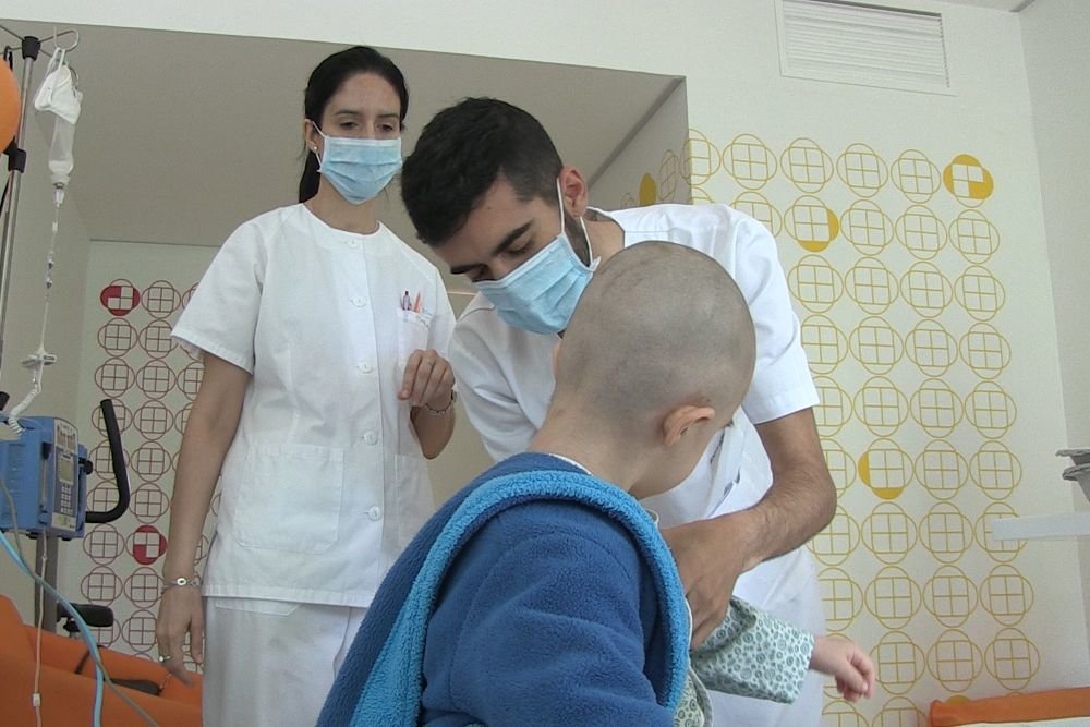 Dos médicos tratan a un paciente de cáncer infantil.