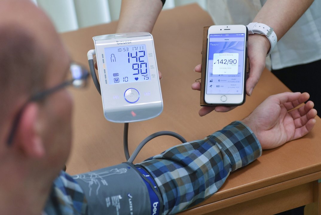 Un hombre recibe en una aplicación de su teléfono móvil los datos de su presión sanguínea.