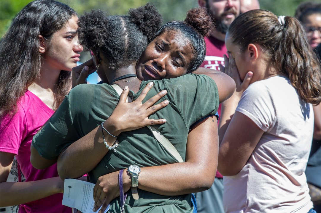 Dos jóvenes se abrazan durante la ceremonia en memoria de las víctimas del tiroteo de Florida.