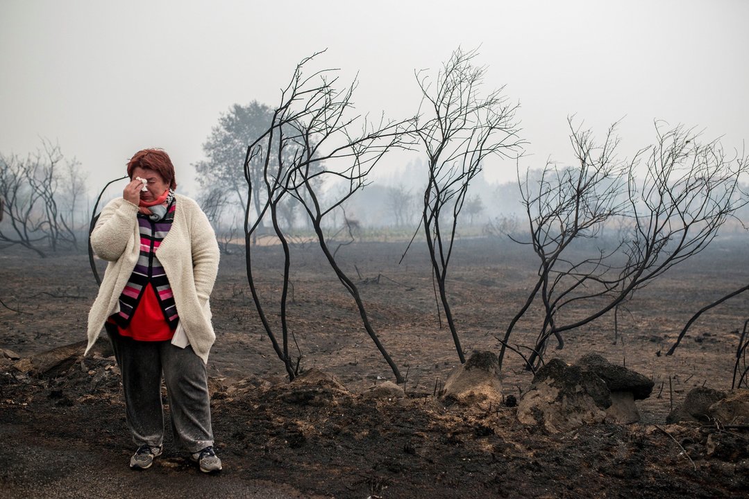 Una mujer llora ante un paraje calcinado por el fuego en Carballeda de Avia, el pasado octubre.