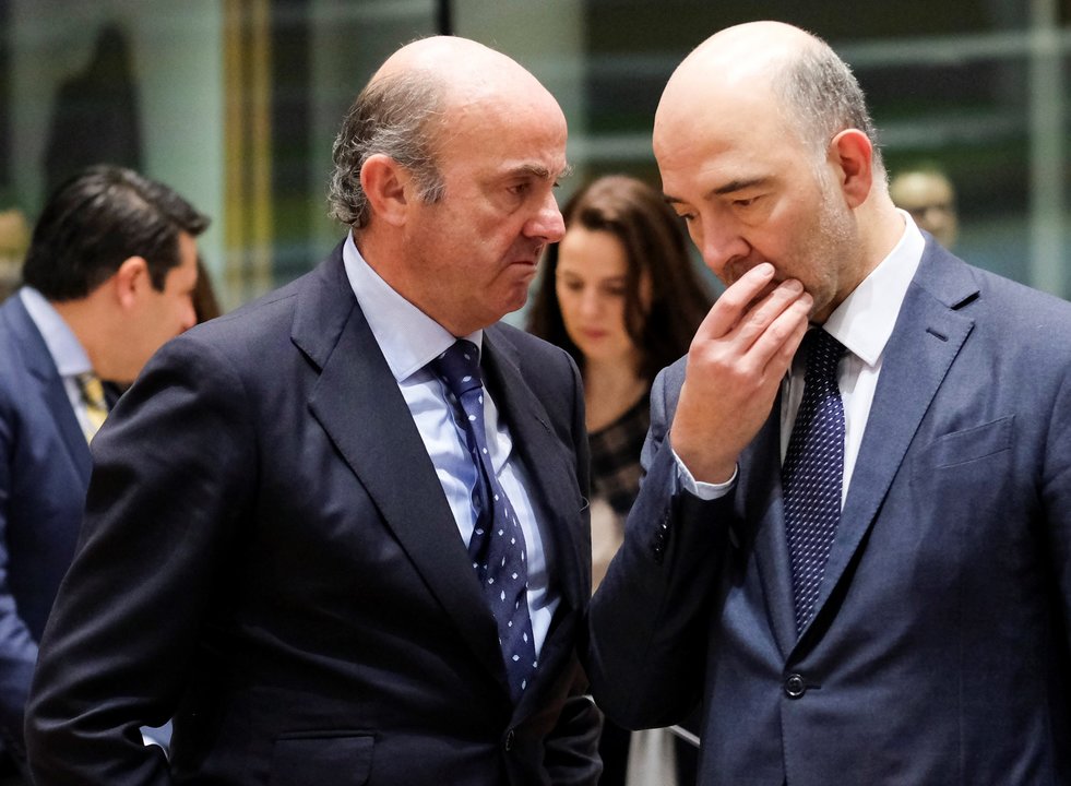 Luis de Guindos conversa en Bruselas con el comisario europeo Moscovici.