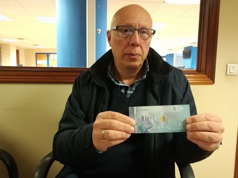 Miguel Estévez portando un billete con 0,1 gramos de oro.