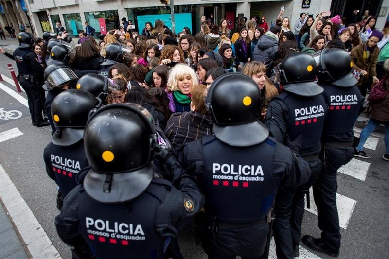 Efectivos de los Mossos d'Esquadra desalojan a un grupo de mujeres que cortaban la Gran Via de Barcelona
