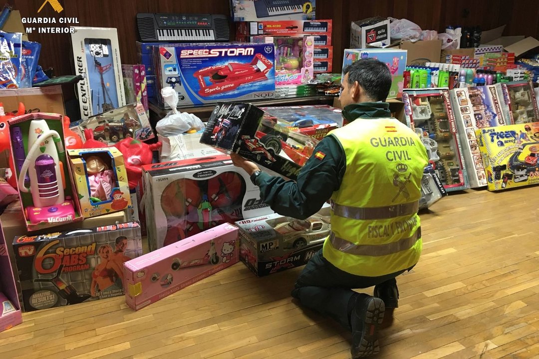 Un agente de la Guardia Civil realiza un registro en una tienda de juguetes.