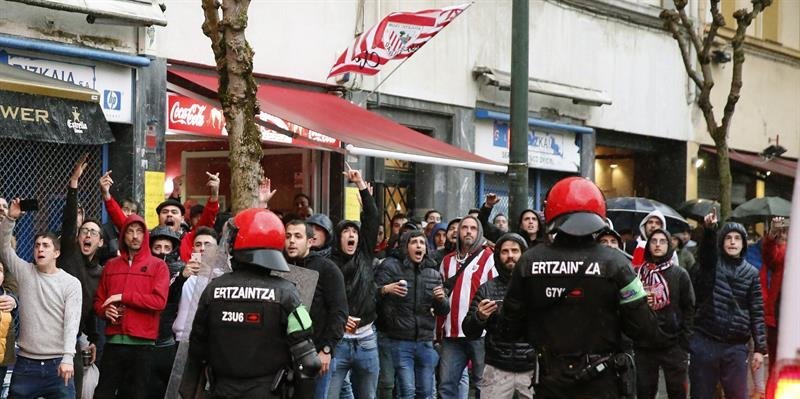 Aficionados del Athletic ante agentes de la Ertzaintza en las inmediaciones del estadio de San Mamés
