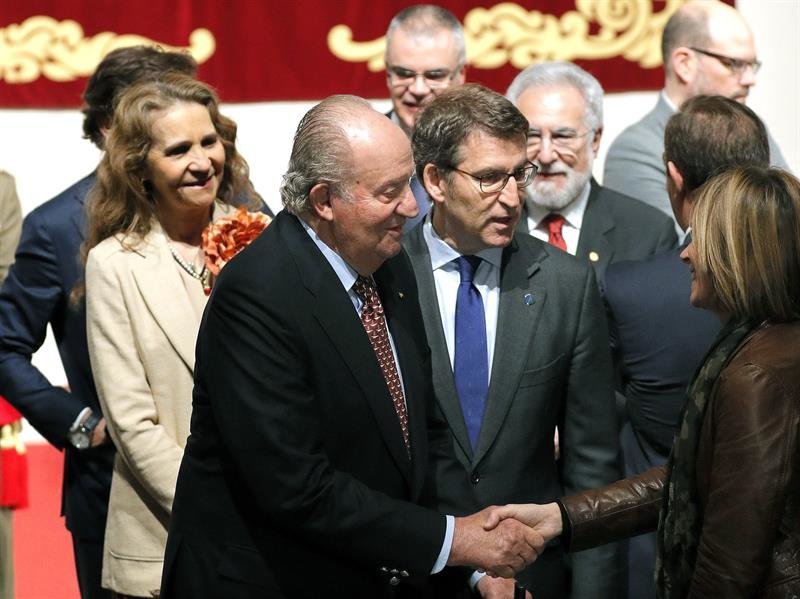 El rey Juan Carlos saluda a la directora de Turismo de Galicia, Nava Castro (d), acompañado por la Infanta Elena (i) y el titular del Gobierno gallego, Alberto Núñez Feijóo, tras recibir la credencial como embajador de honor del Camino de Santiago