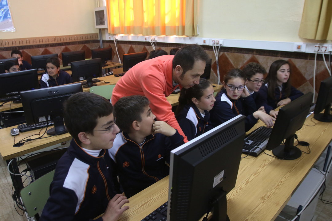 Un profesor y sus alumnos, en un aula de informática.