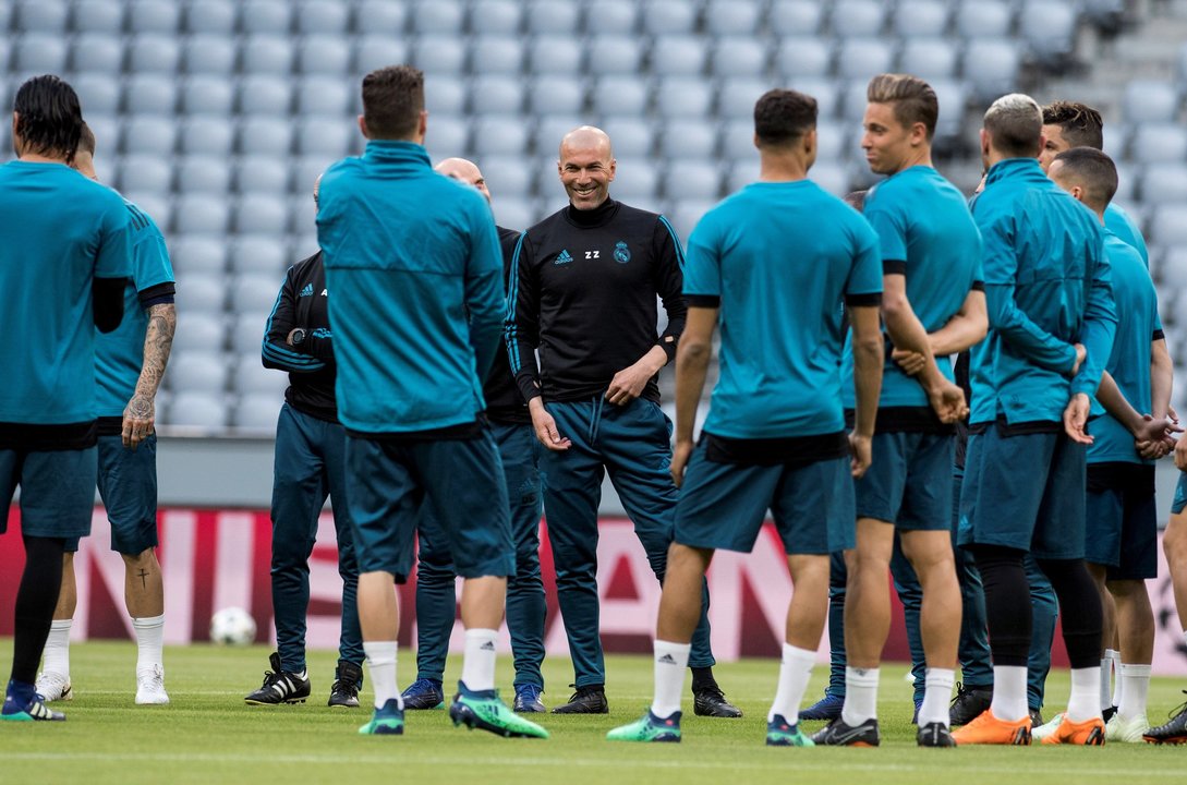 La plantilla del Real Madrid escucha a Zinedine Zidane en el entrenamiento de ayer en el Allianz Arena.