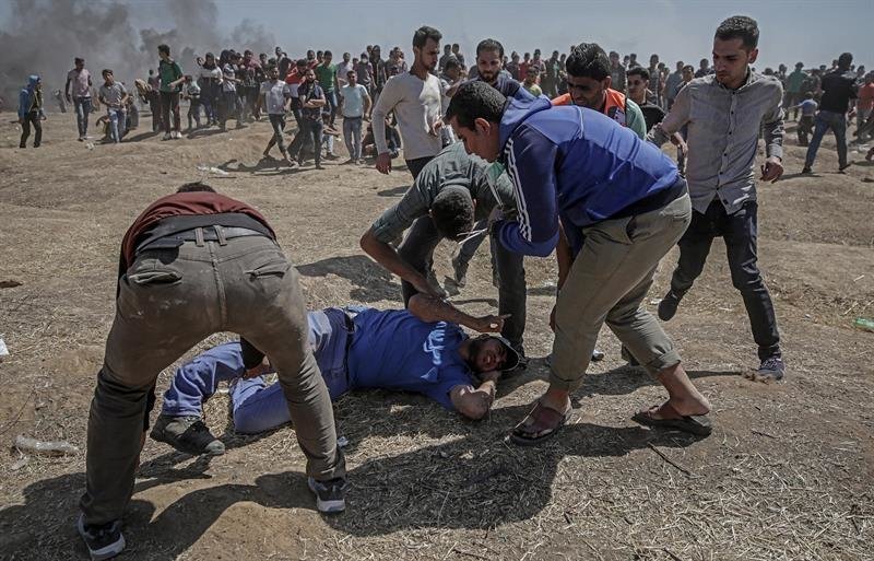 Manifestantes palestinos tratan de ayudar a un herido durante enfrentamientos