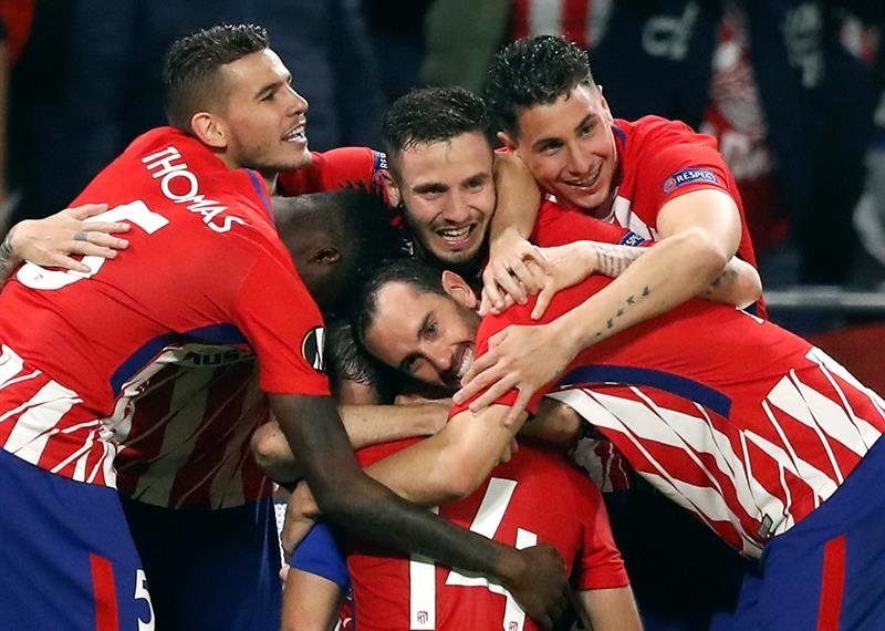 Jugadores de Atlético celebran al vencer 3-0 a Olympique