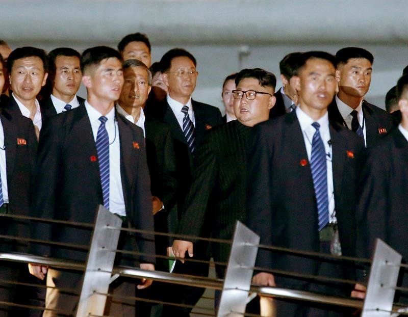 El líder norcoreano, Kim Jong-un (centro-dch), y el ministro de Exteriores de Singapur, Vivian Balakrishnan (centro-izq), cruzan a pie el puente Jubilee en la Esplanade, en Singapur