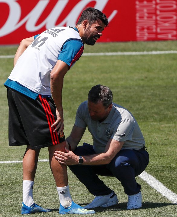 El doctor Cota atiende a Diego Costa, ayer, en el entrenamiento.