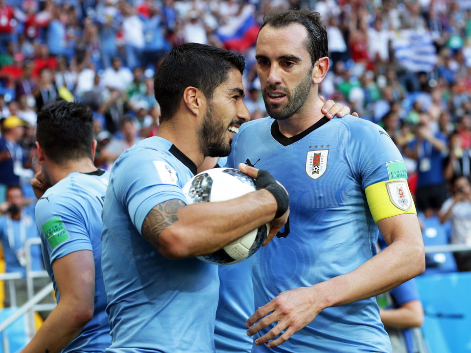 Luis Suárez celebra su gol con su compañero Godín.