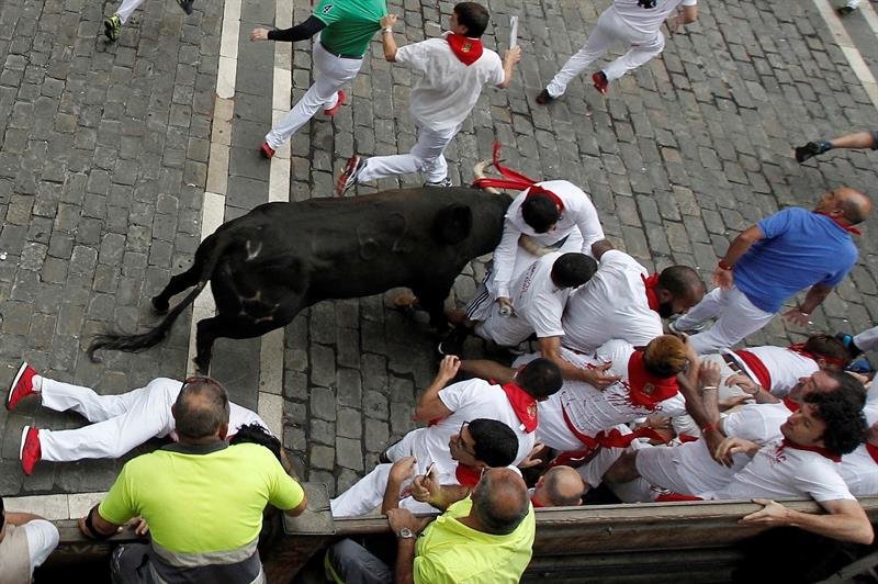 Un toro de la ganadería extremeña de Jandilla arrolla a un mozo en el tramo de la Plaza Consistorial de Pamplona durante el séptimo encierro