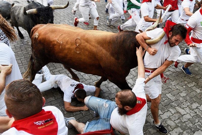 Un corredor es arrastrado por un toro durante San Fermín