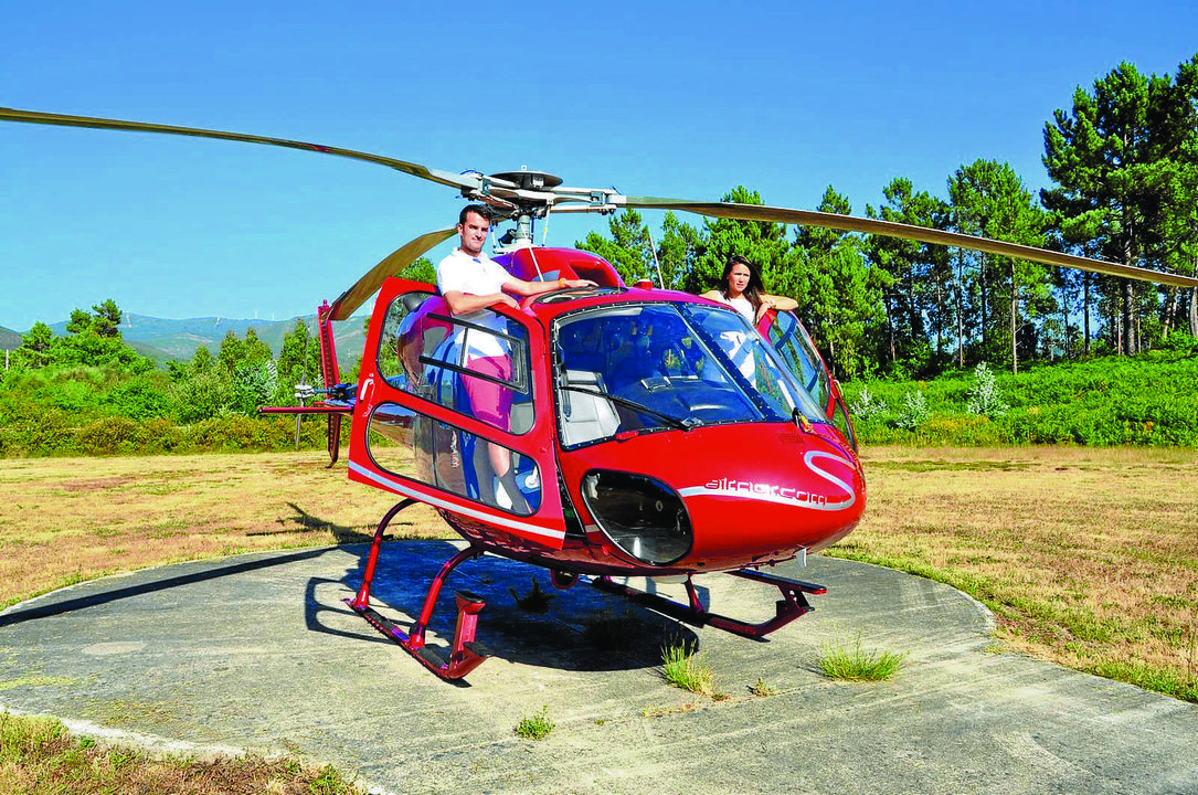 César Dorado con una clienta, a punto de entrar en el helicóptero para realizar una de las rutas.