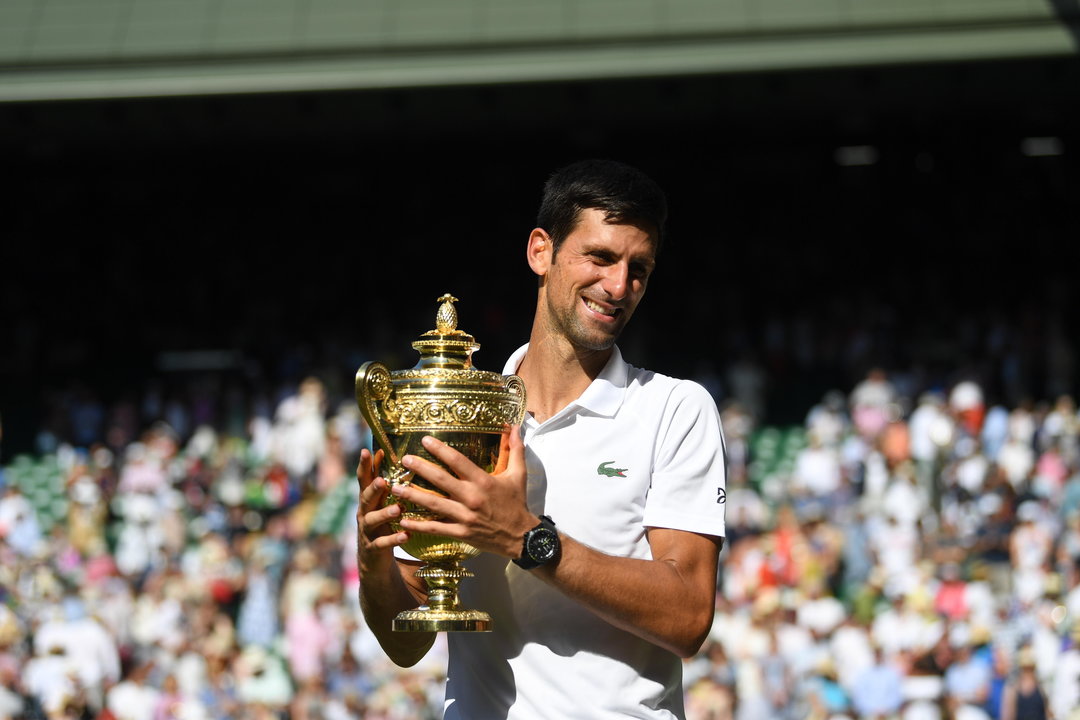 Djokovic disfruta, sonriente, con su cuarto trofeo de Wimbledon.
