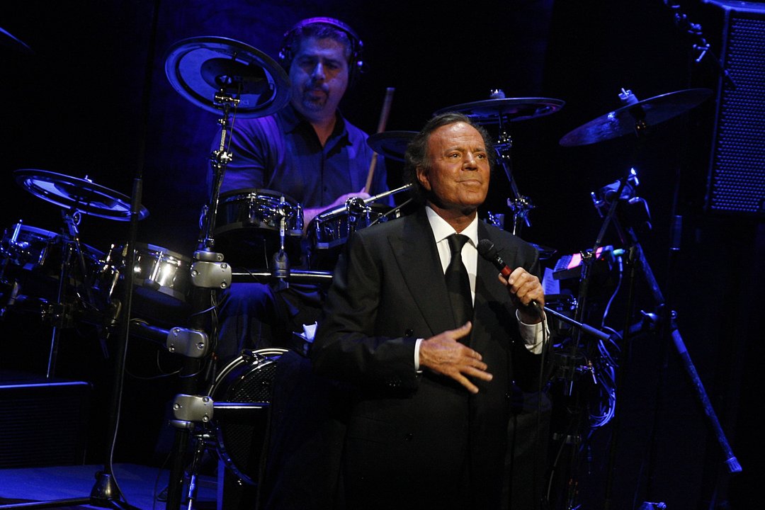 Julio Iglesias, con su característico pose, en el transcurso de un concierto.