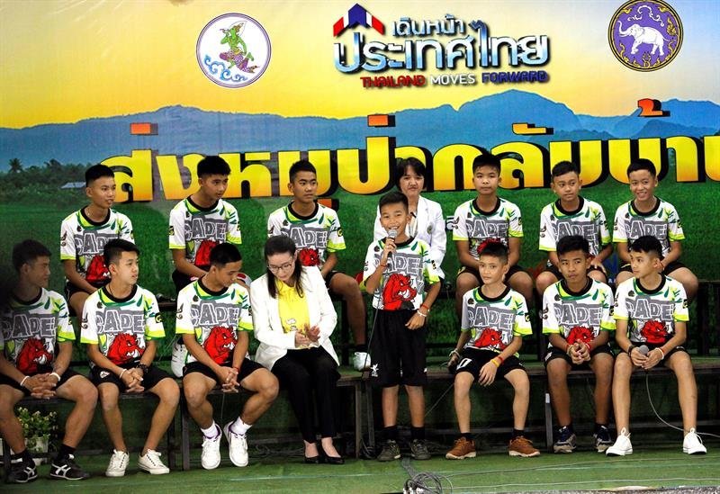 Los doce niños y su entrenador rescatados del interior de una cueva en el norte de Tailandia se dirigen a los medios durante su primera aparición pública junto a psicólogos infantiles