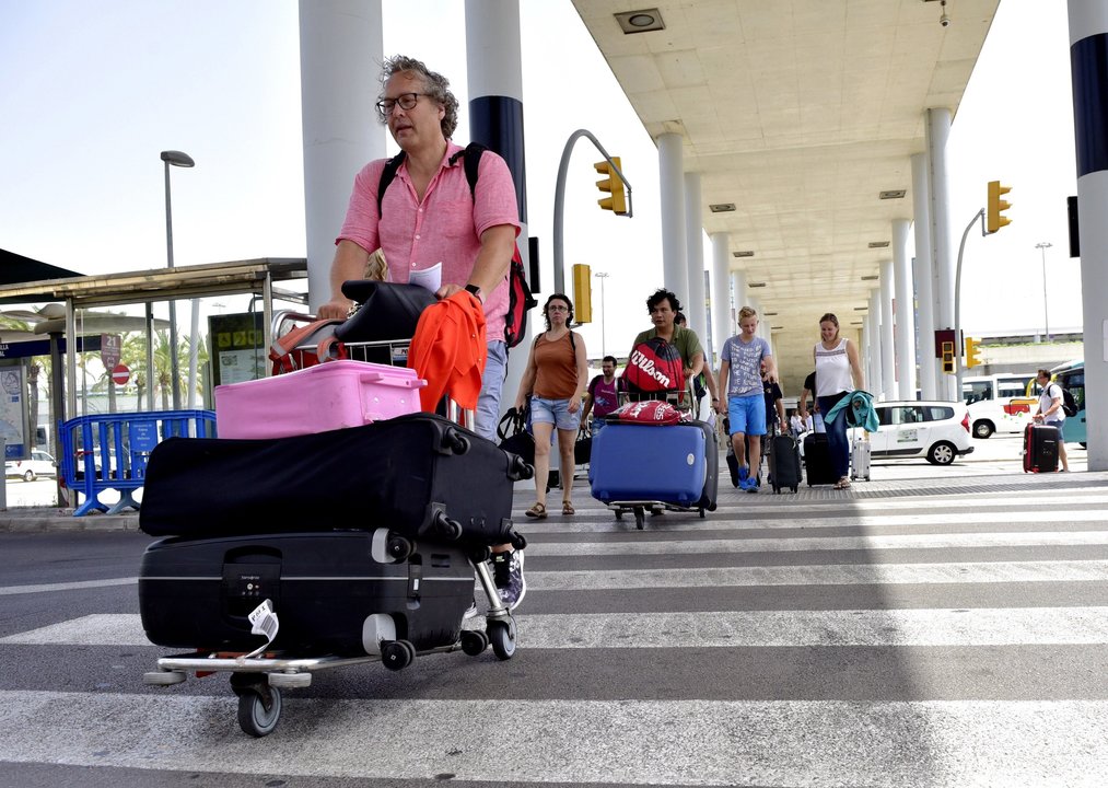 Turistas, transportando sus maletas, a su llegada al aeropuerto de Palma de Mallorca.
