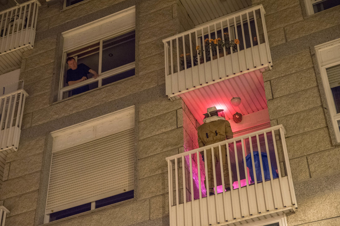 Los bomberos retirando un nido de avispa velutina del balcón de un edificio en Ourense.