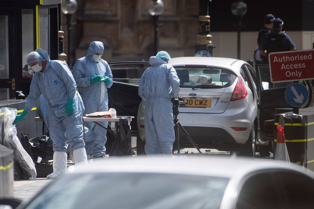 Oficiales forenses examinan el coche que chocó contra las barreras del Parlamento británico.