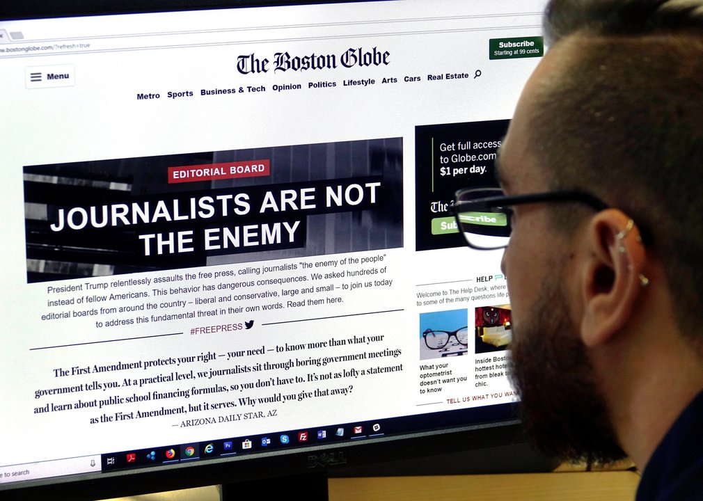 Un hombre consulta el editorial de The Boston Globe en el que se lee &#34;Los periodistas no son el enemigo&#34;