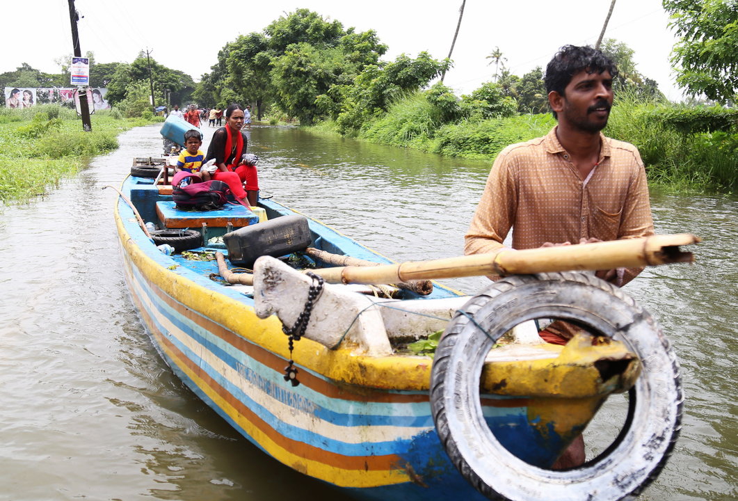 Una familia se traslada en una típica barca del país en busca un refugio más seguro.