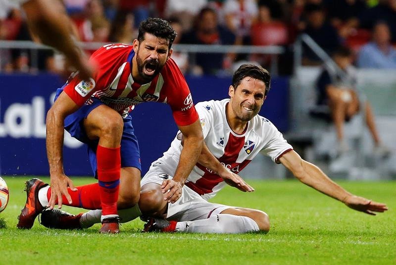 El delantero del Atlético de Madrid Diego Costa (i) se duele tras la entrada de Xabier Etxeita
