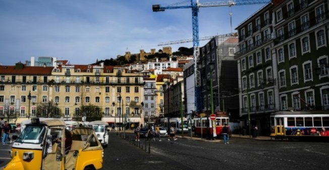 Unas grúas de obras de rehabilitación de edificios trabajan en la plaza Figueira, en Lisboa.
