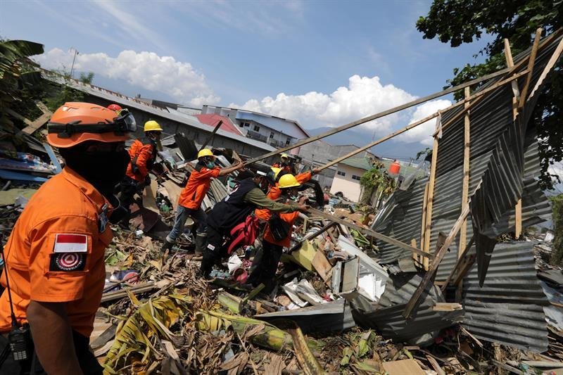 Los trabajadores de la Agencia Nacional de Búsqueda y Rescate de Indonesia (BASARNAS) buscan cuerpos bajo las ruinas