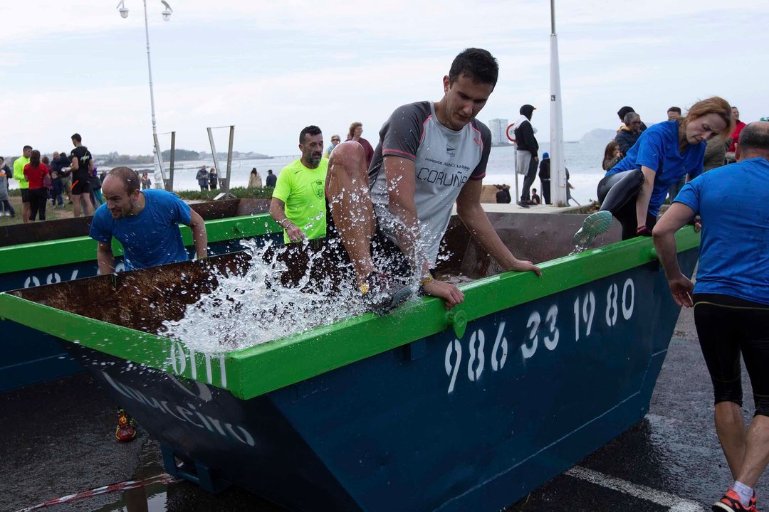 Contenedores llenos de agua se reconvirtieron en obstáculos para los numerosos deportistas que aceptaron el desafío en la playa de Samil.