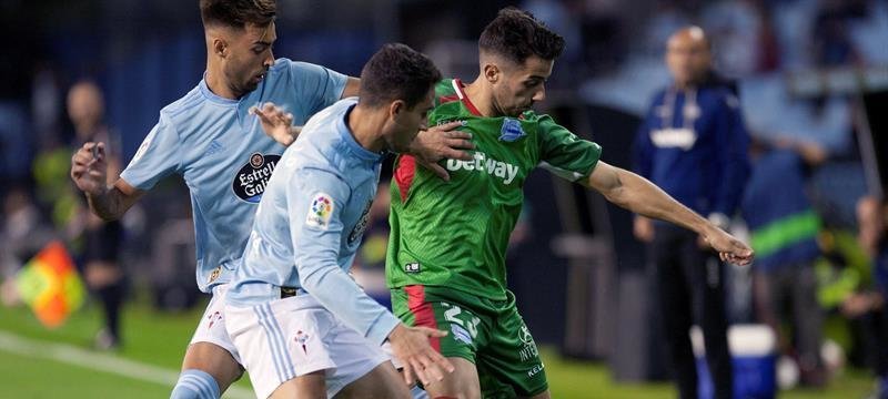El defensa del Celta de Vigo, Hugo Mallo (c), pugna por un balón con el centrocampista del Alavés, Jony Rodríguez (d)