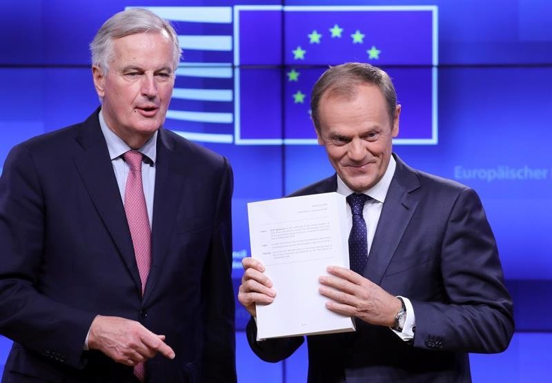 El negociador jefe europeo para el &#34;brexit&#34;, Michel Barnier (izq), entrega el borrador del acuerdo para la salida del Reino Unido de la UE al presidente del Consejo Europeo, Donald Tusk (dcha)