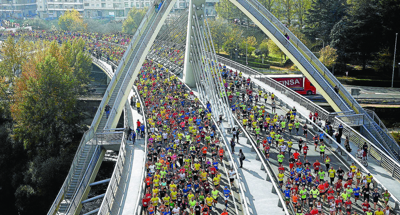 Os atletas cruzan a Ponte do Milenio ó inicio da edición 2018 da Carreira Pedestre Popular de San Martiño.