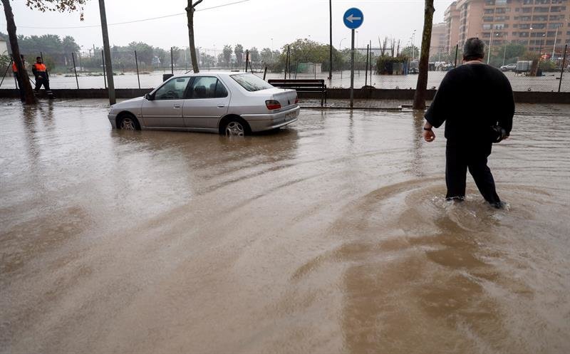 Una persona cruza una calle inundada
