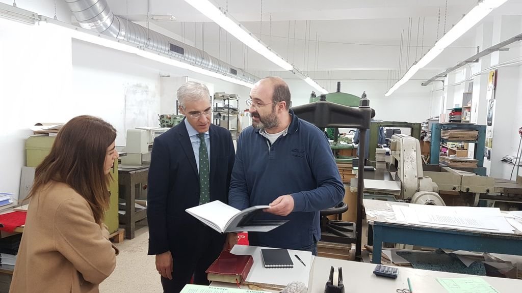 El conselleiro de Economía, Francisco Conde, visitó el taller Pino Encuadernaciones, donde Pablo Otero le mostró el trabajo que realizan.