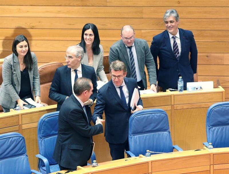 El presidente de la Xunta de Galicia, Alberto Núñez Feijóo (c), felicita al conselleiro de Facenda de la Xunta, Valeriano Martínez (i), después de que se aprobaran los presupuestos de Galicia