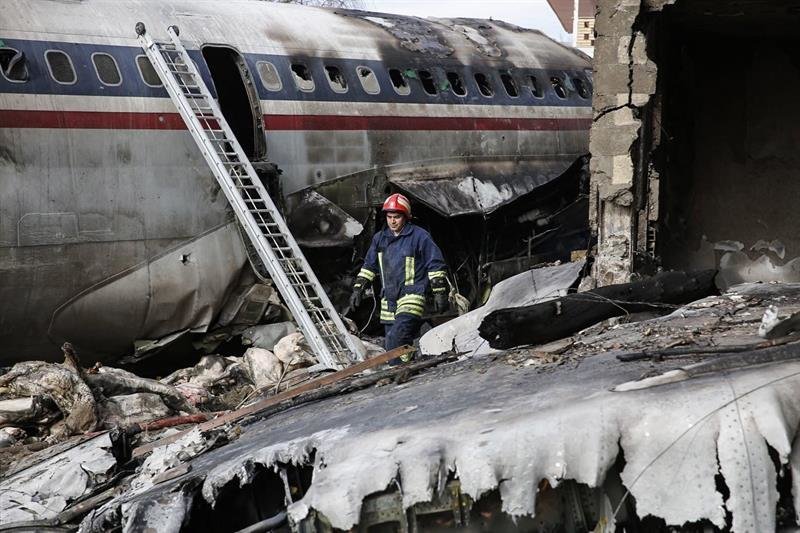 Un bombero camina entre los restos del fuselaje de un avión de carga Boeing 707 que se estrelló cerca de la ciudad de Karag, al oeste de Teherán