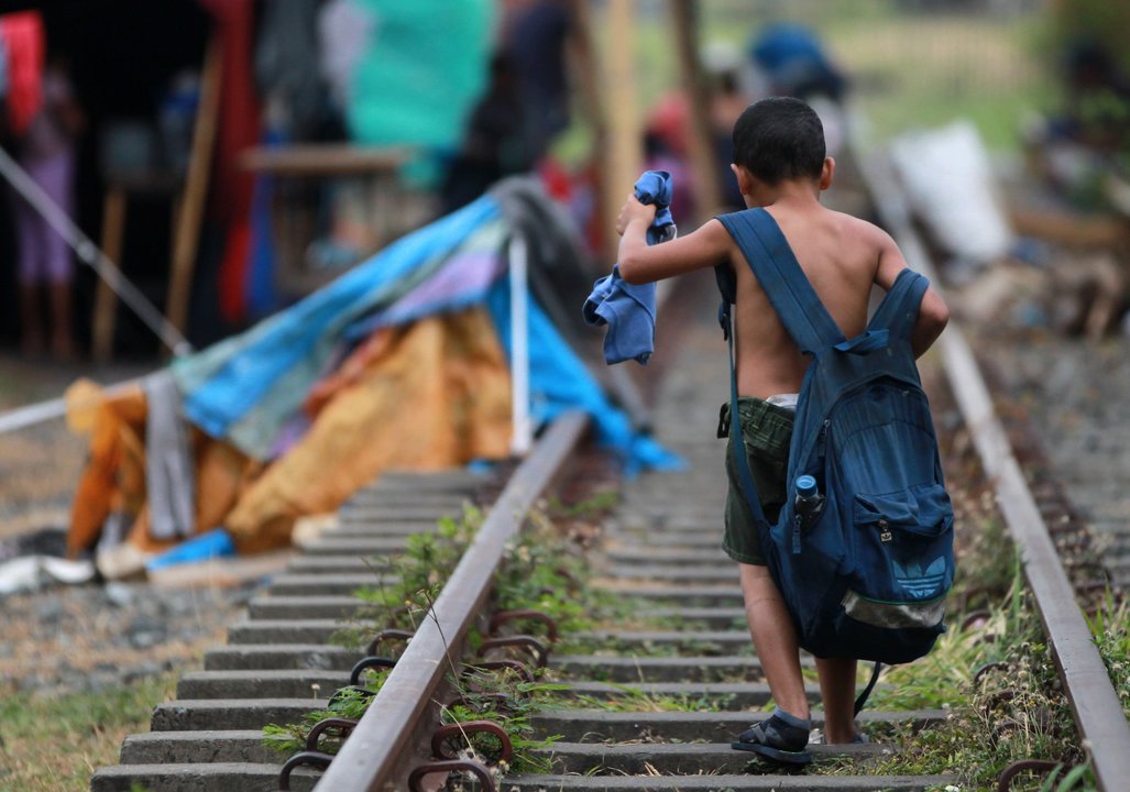 Un niño camina por las vías del tren cerca de un campamento de venezolanos en Colombia.