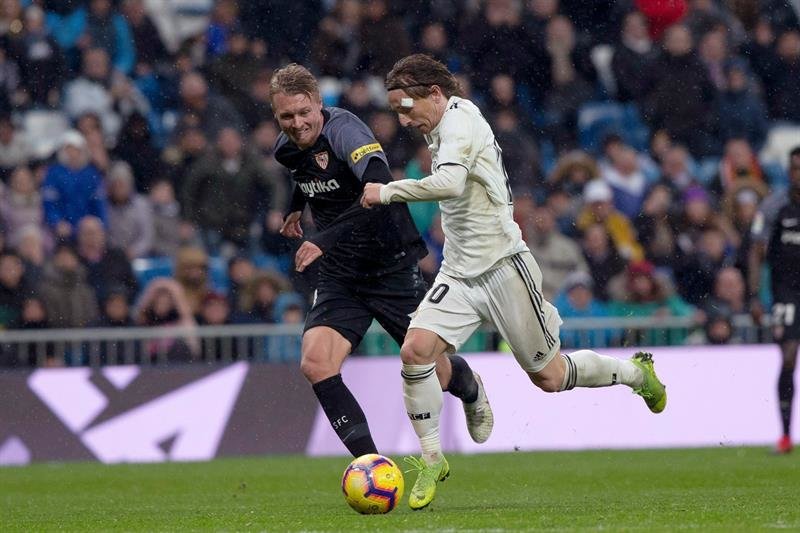 El centrocampista croata del Real Madrid, Luka Modric (d), lucha por el balón ante el defensa portugués del Sevilla FC, Daniel Carriço (i)