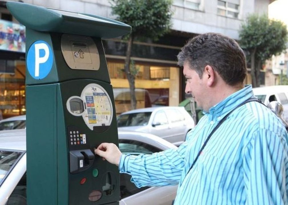 Un conductor paga su ticket en un parkímetro en Vigo, donde la tarifa es de 0,30 euros minuto.