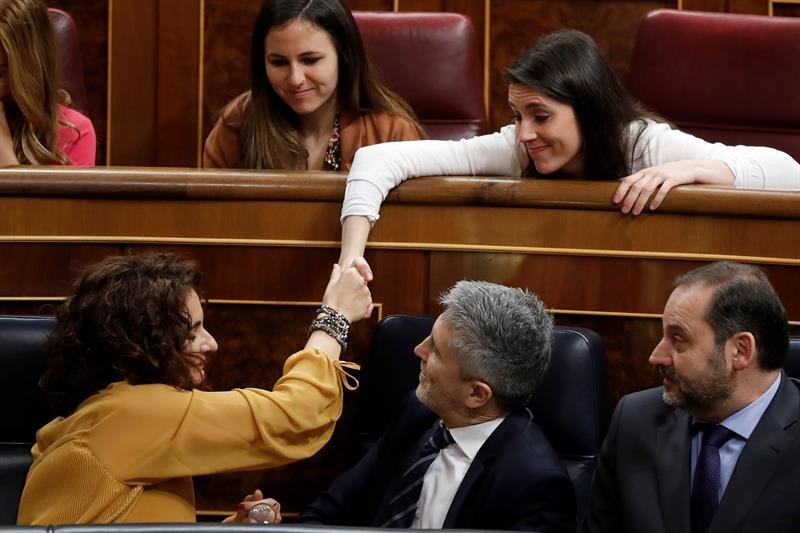 La ministra de Hacienda, María Jesús Montero (i - 1ªfila), estrecha la mano con la portavoz de Podemos en el Congreso, Irene Montero (d - 2ª fila)