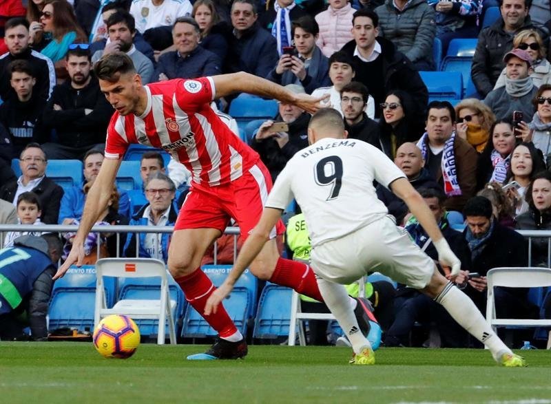 El defensa del Girona, Pedro Alcalá (i), controla el balón ante el delantero francés del Real Madrid, Karim Benzema (d)