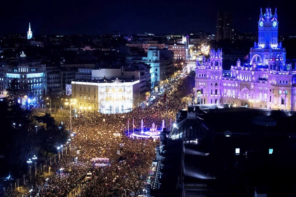 Miles de personas abarrotaron el centro de Madrid, con sus monumentos iluminados de morado.