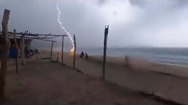 Momento en el que cae un rayo en una playa de México. // Twitter