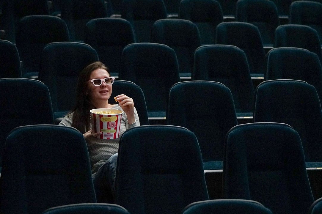 Una mujer disfruta de una película en el cine con sus palomitas. // Pixabay