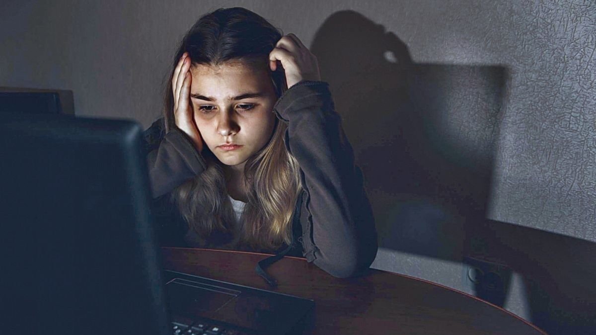 Una joven se muestra preocupada mientras usa un ordenador.