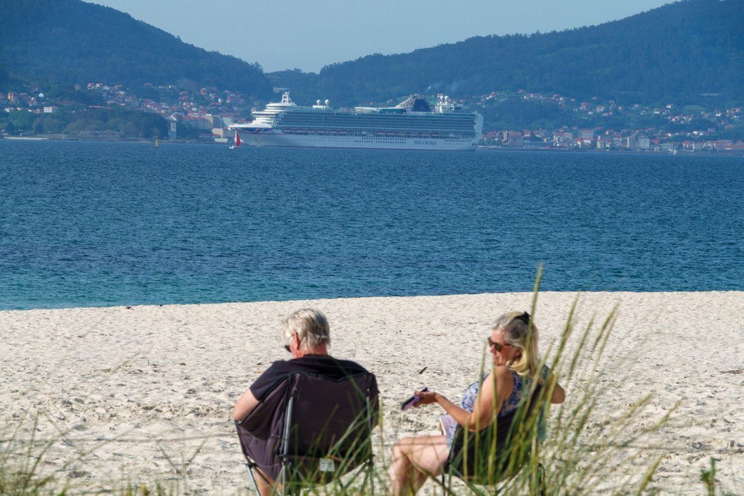 Dos personas disfrutan del buen tiempo en una playa de Vigo. // Vicente Alonso
